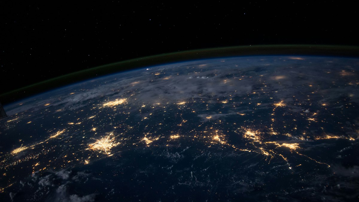 An artist's rendering of a laser beam transmitting data between a deep space probe and a high-altitude mountain observatory on Earth.